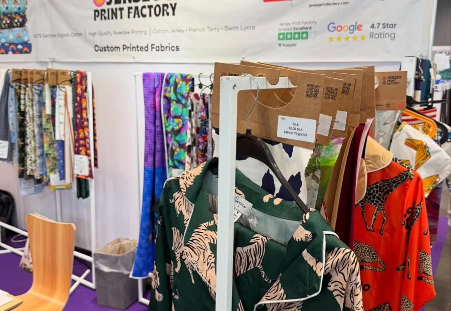 Jersey Print Factory'nin tekstil fuarındaki standı, askıda baskılı kumaşlar