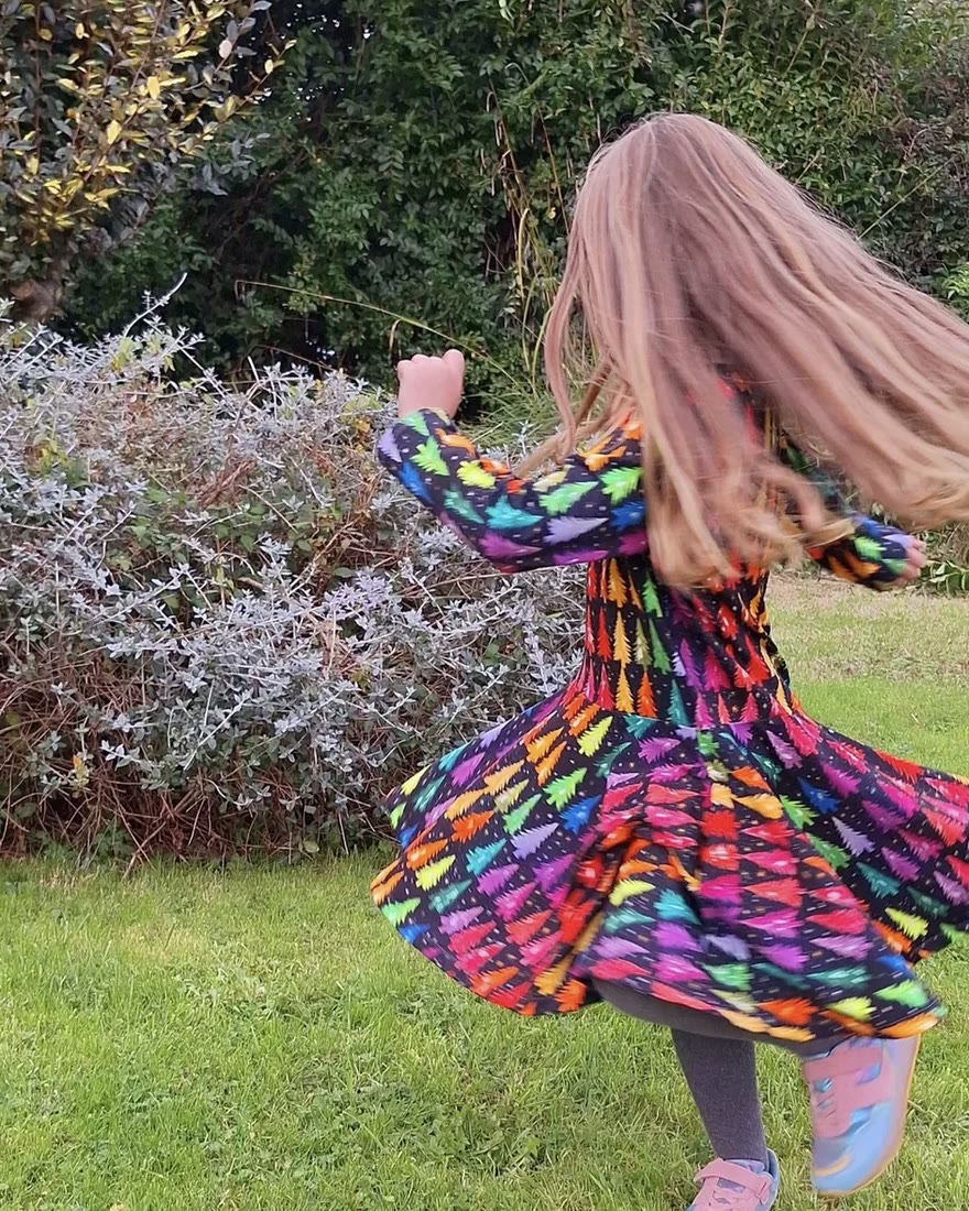 A child’s dress sewn from a customer’s own print, mid-twirl